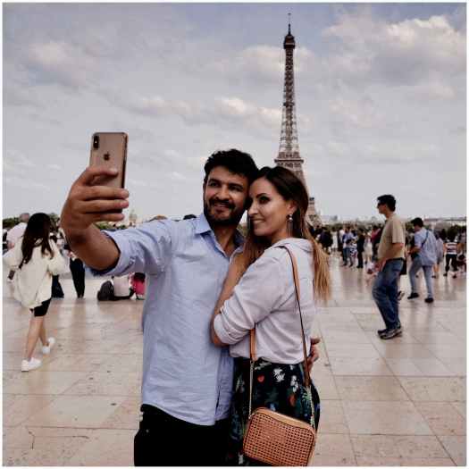 photo of a man and woman taking selfie with background of eiffel tower of paris